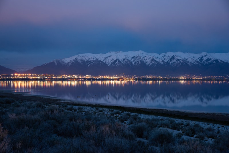 Reflection of city lights in the water at night at Antelope Island