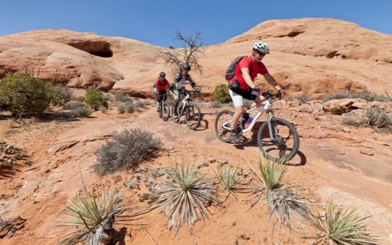 father and two sons mountain biking in Moab