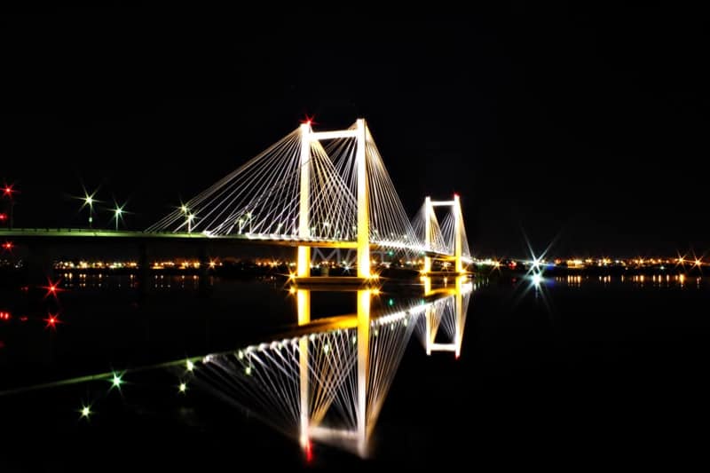 lights on a bridge at night reflected in the water