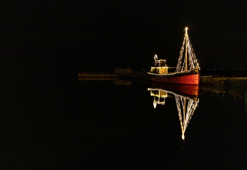 a boat with lights surrounded by dark night