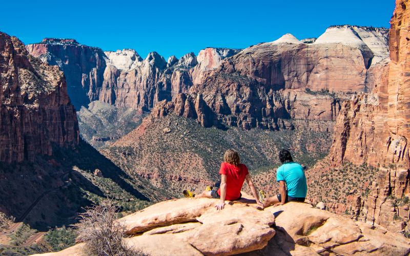 two hikers enjoying the view along the Canyon Overlook trail at Zion
