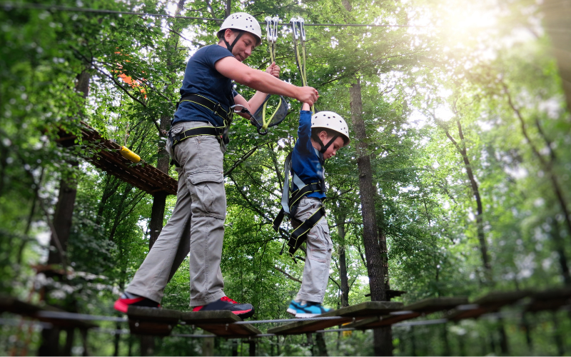 man and boy doing a ropes course