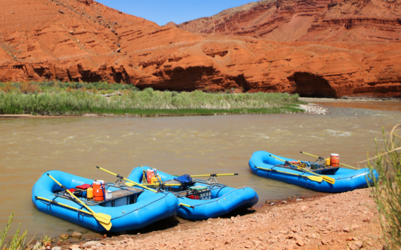 3 rafts docked on a beach along the Colorado River in Moab Utah