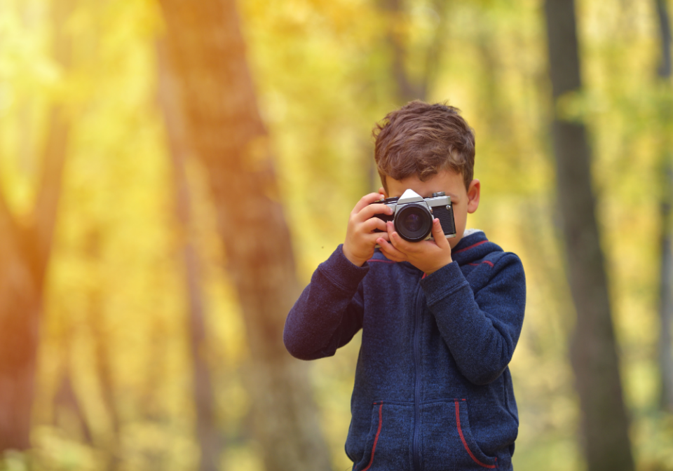boy taking pictures in the fall