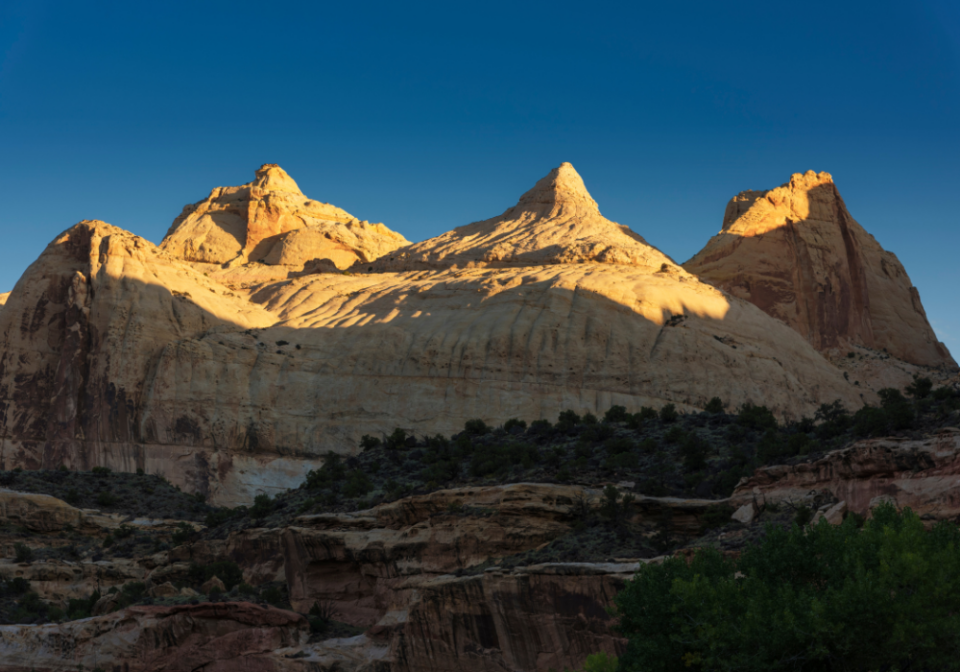 Light on the top of the Capitol Reef rock formations along Highway 24 at sunrise 
